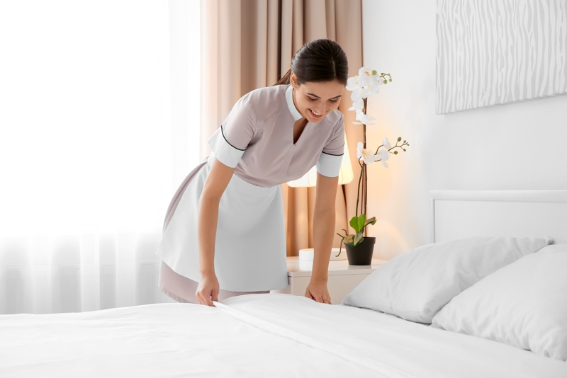 Cropped image of a young hotel maid standing and holding fresh clean towels